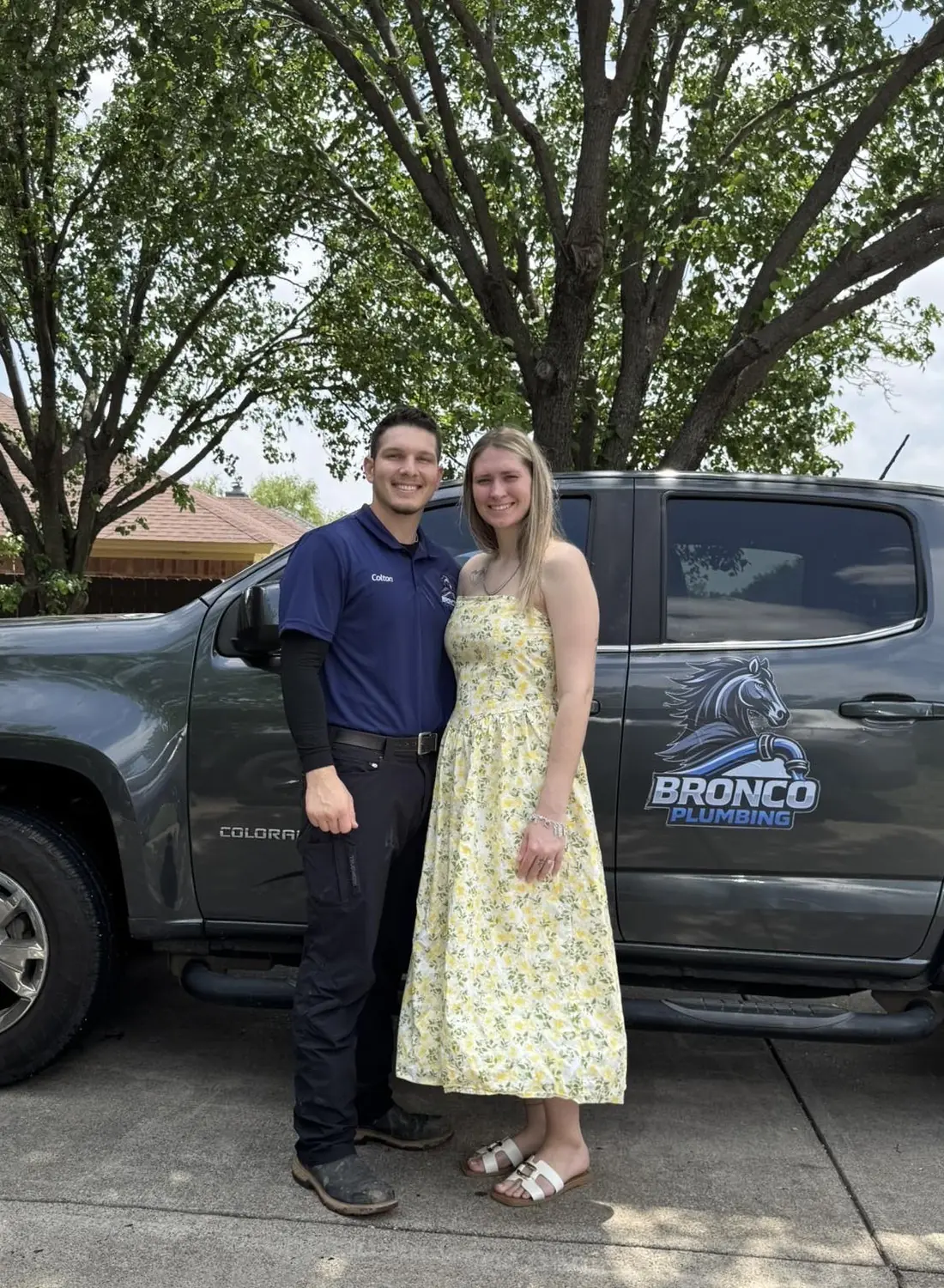 Colton Staley, owner of Bronco Plumbing, with his wife in front of the Bronco work truck