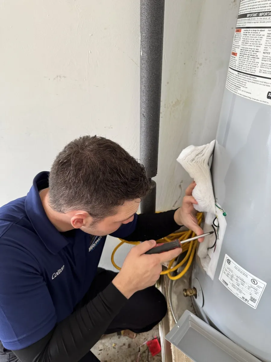 Bronco Plumbing technician inspecting a water heater connection in DFW